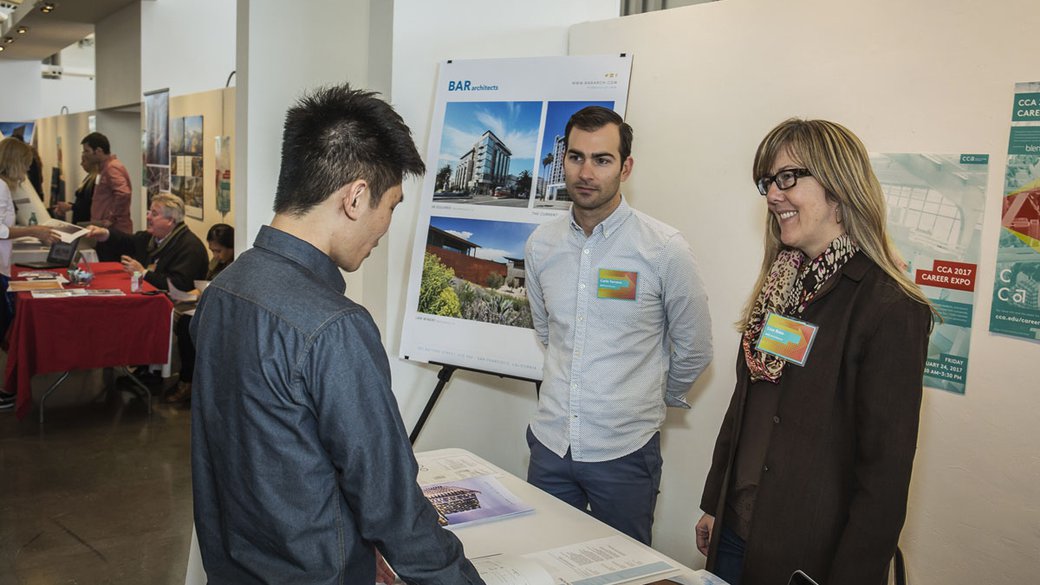 A student talking with associates from BAR Architects
