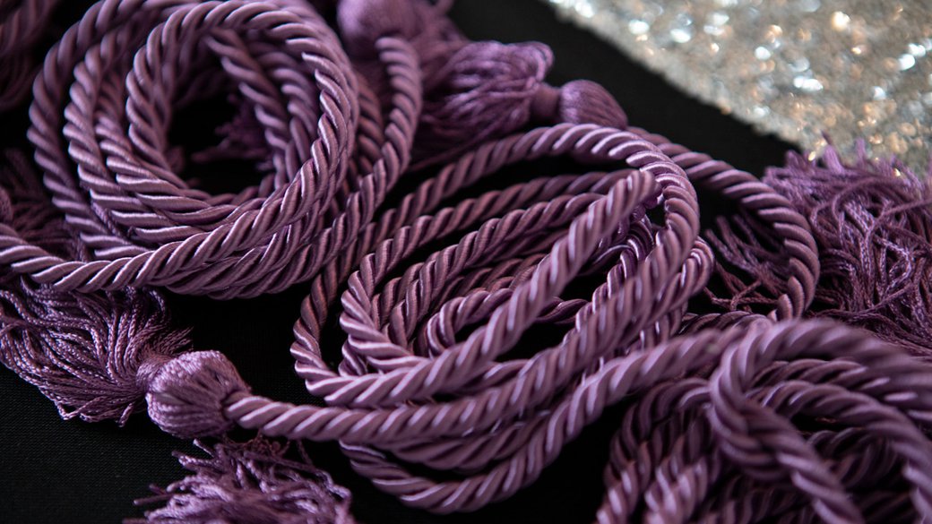 Close-up image of lavender colored ropes with tassels on the end.