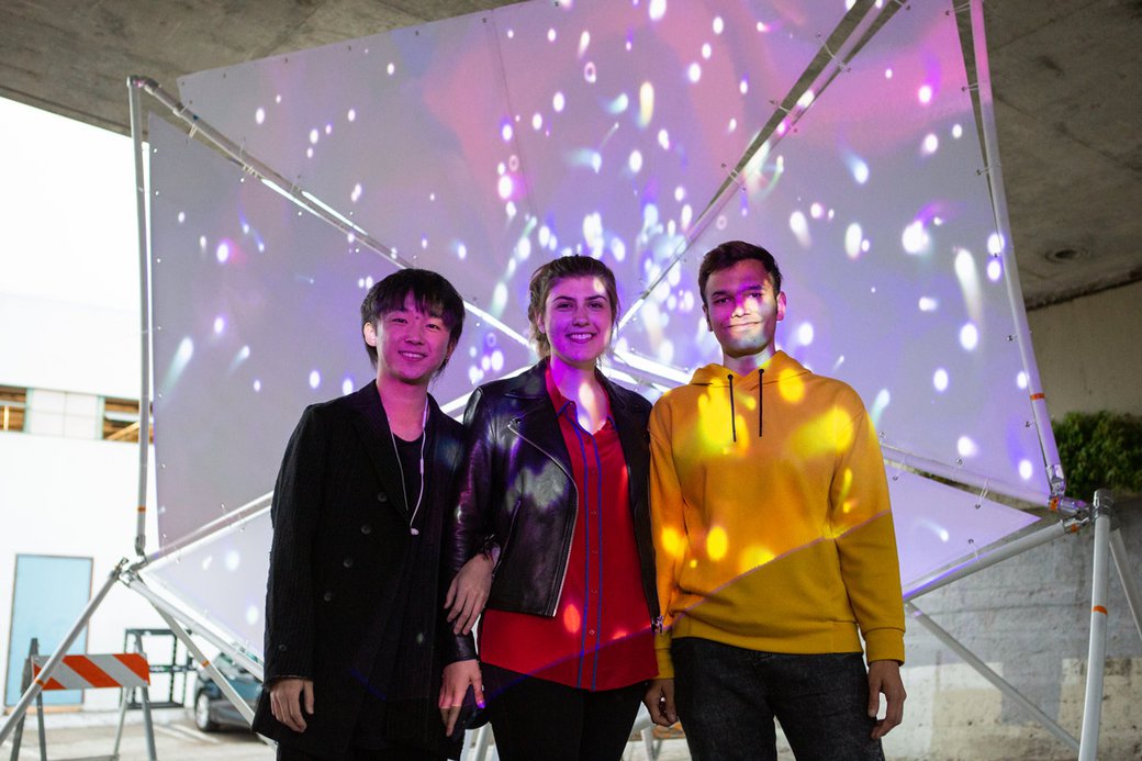 A group of students in front of a projection-mapped installation