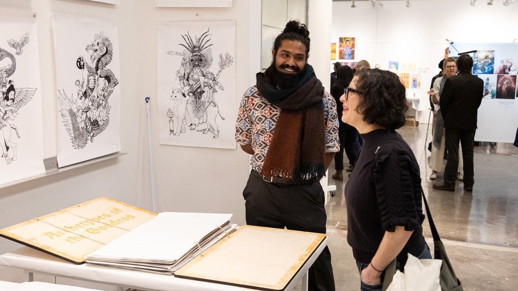 Two people converse in an exhibition space.