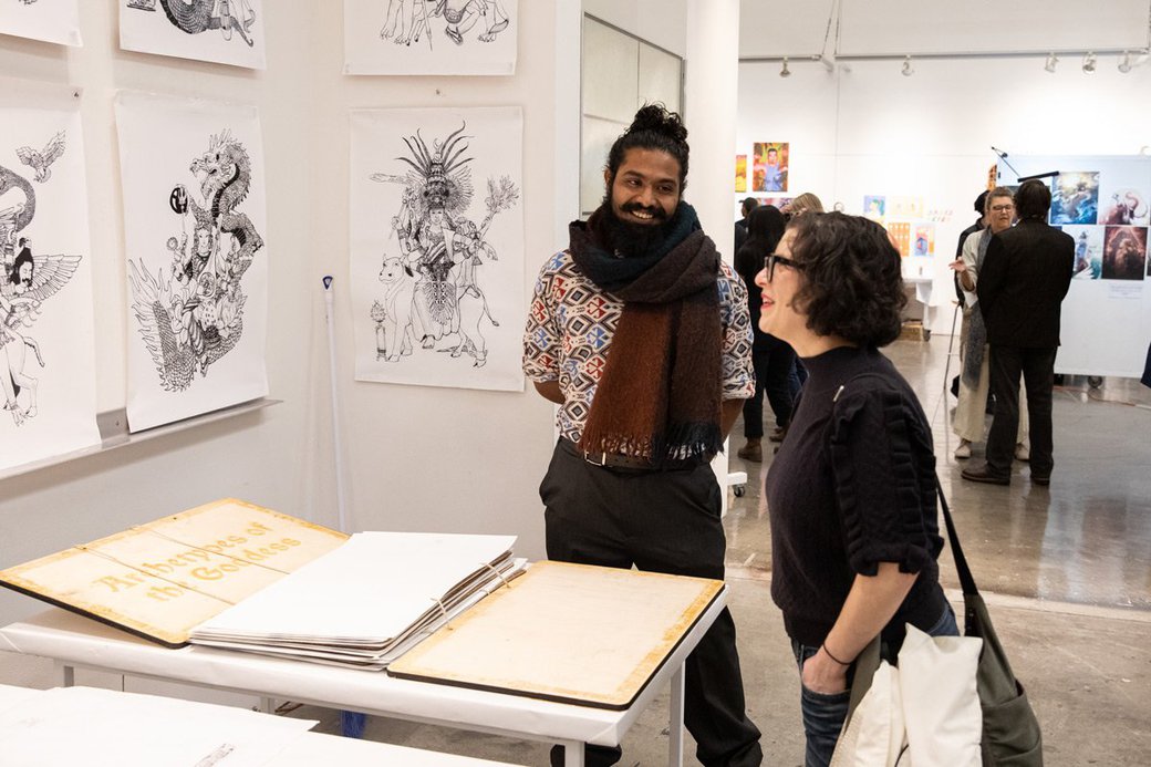 Two people converse in an exhibition space.