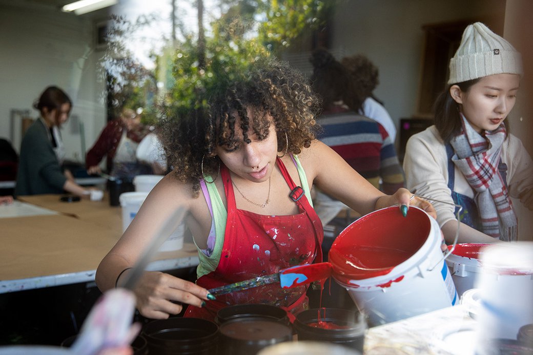 A student pours ink in an introductory screenprinting class.