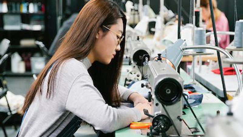 Student sewing in Fashion Design fabric workshop