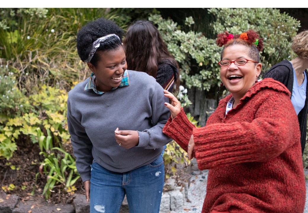 Faith Adiele laughs with a student in the garden.