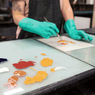 A close-up view of a student mixing printmaking ink.