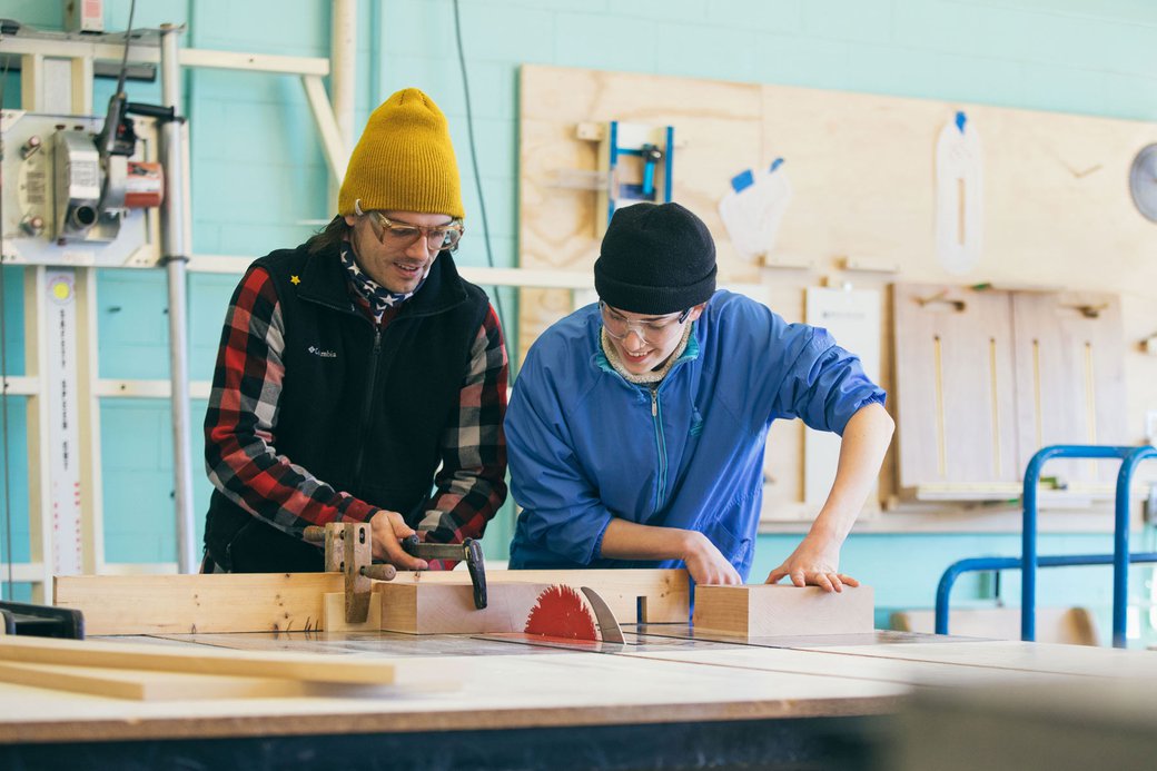 Photograph of two students using a table saw in the First Year Studios Wood Shop.