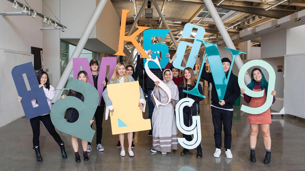 Mark Fox's 'identity' class poses with their 3 foot tall letters in the Nave