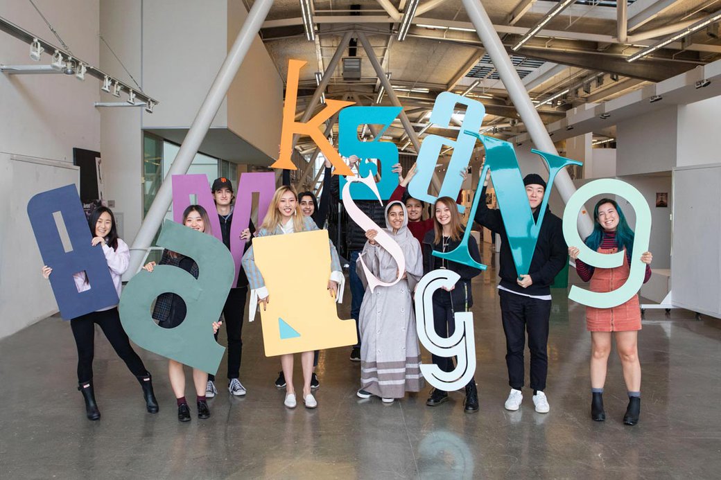Mark Fox's 'identity' class poses with their 3 foot tall letters in the Nave