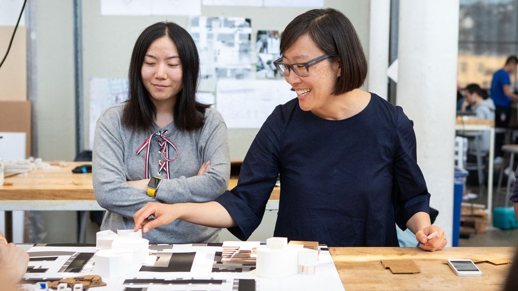 Janette Kim smiling while giving critique to a student.
