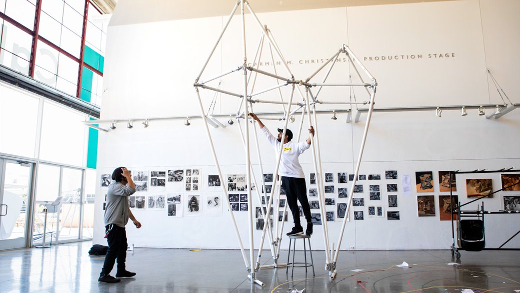 Architecture students work on a 15 foot tall pvc pipe structure