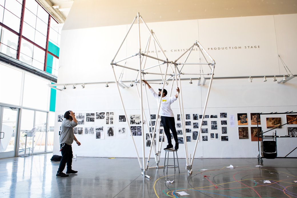 Architecture students work on a 15 foot tall pvc pipe structure