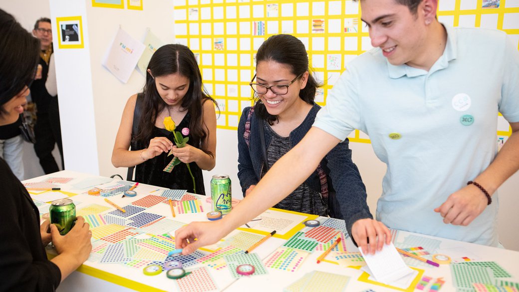 students collaborating on a project during a graphic design show.