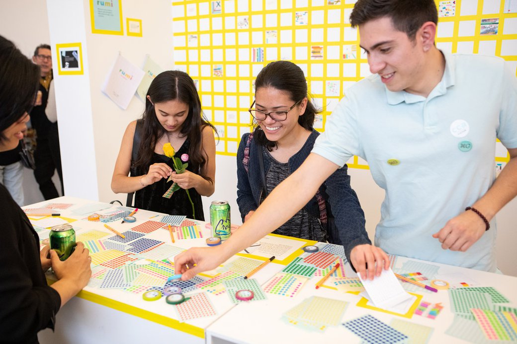 Four students do a collaborative activity around a table with stickers.