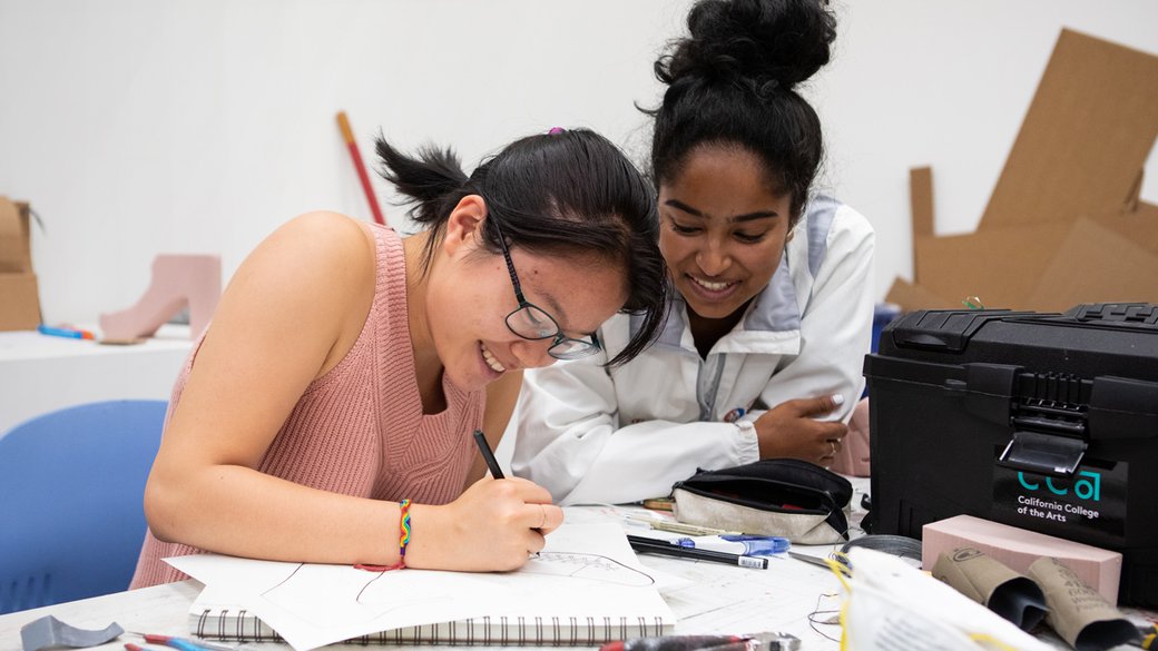 Two students work on their shoe design together.