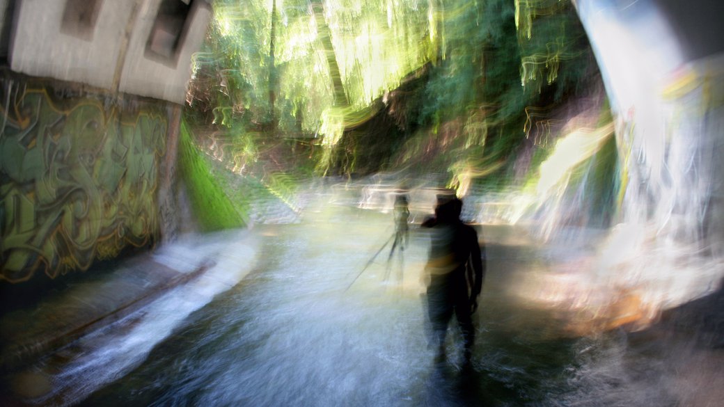 A photographer takes a photo using a tripod inside of a tunnel.