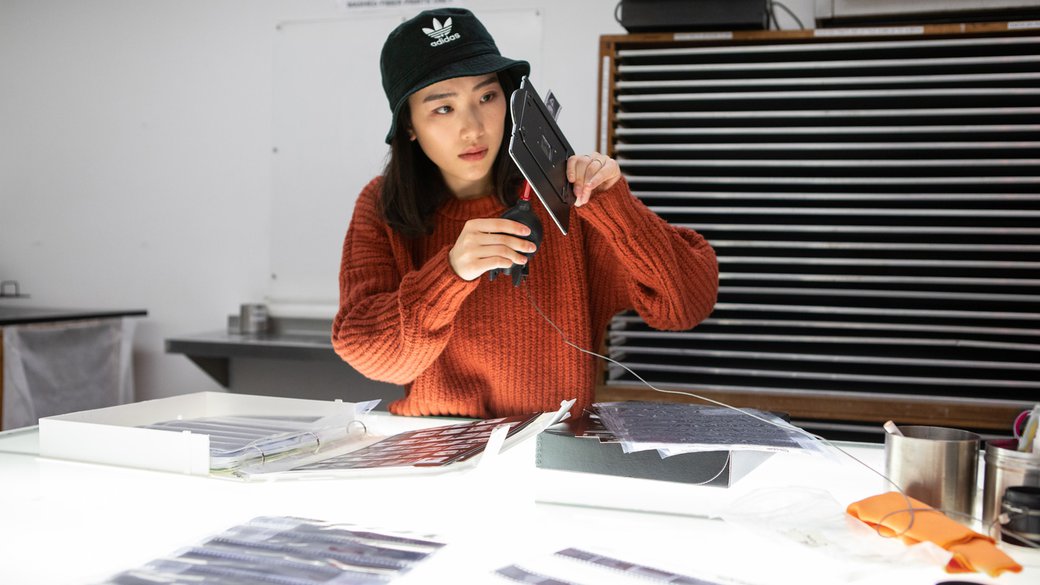 A student examines her negatives outside of the darkroom facility.