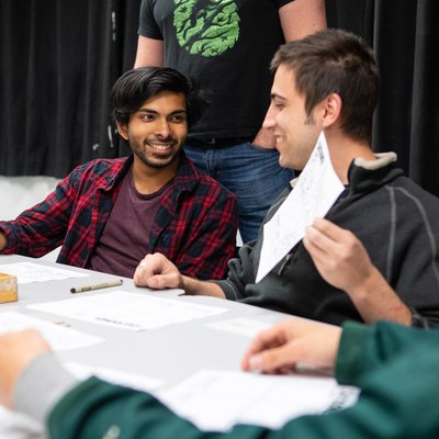 Two writing students laugh about the comics they've created in class.