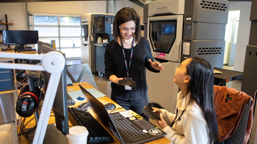 Negar Kalantar laughs with a student in a rapid prototyping lab.