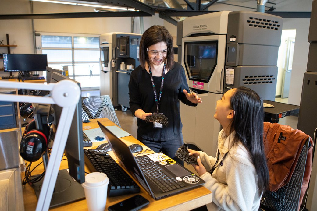 Negar Kalantar laughs with a student in a rapid prototyping lab.
