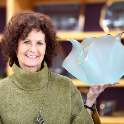Artist Annie Morhauser, holds a glass tulip sculpture with 24-karat gold detail, at her family-owned production studio in Watsonville, California.
