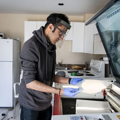 Image of Rahim Bhimani fabricating a face shield that he designed.