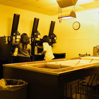 View of Black-and-White Darkroom, range of enlarging stations and two print washers