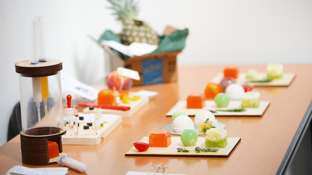 A photo of unnatural-looking food and scientific tools on a table in a futuristic setting.