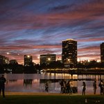 A panoramic photo of Oakland’s Lake Merritt at dusk, with the city’s skyline in the background.