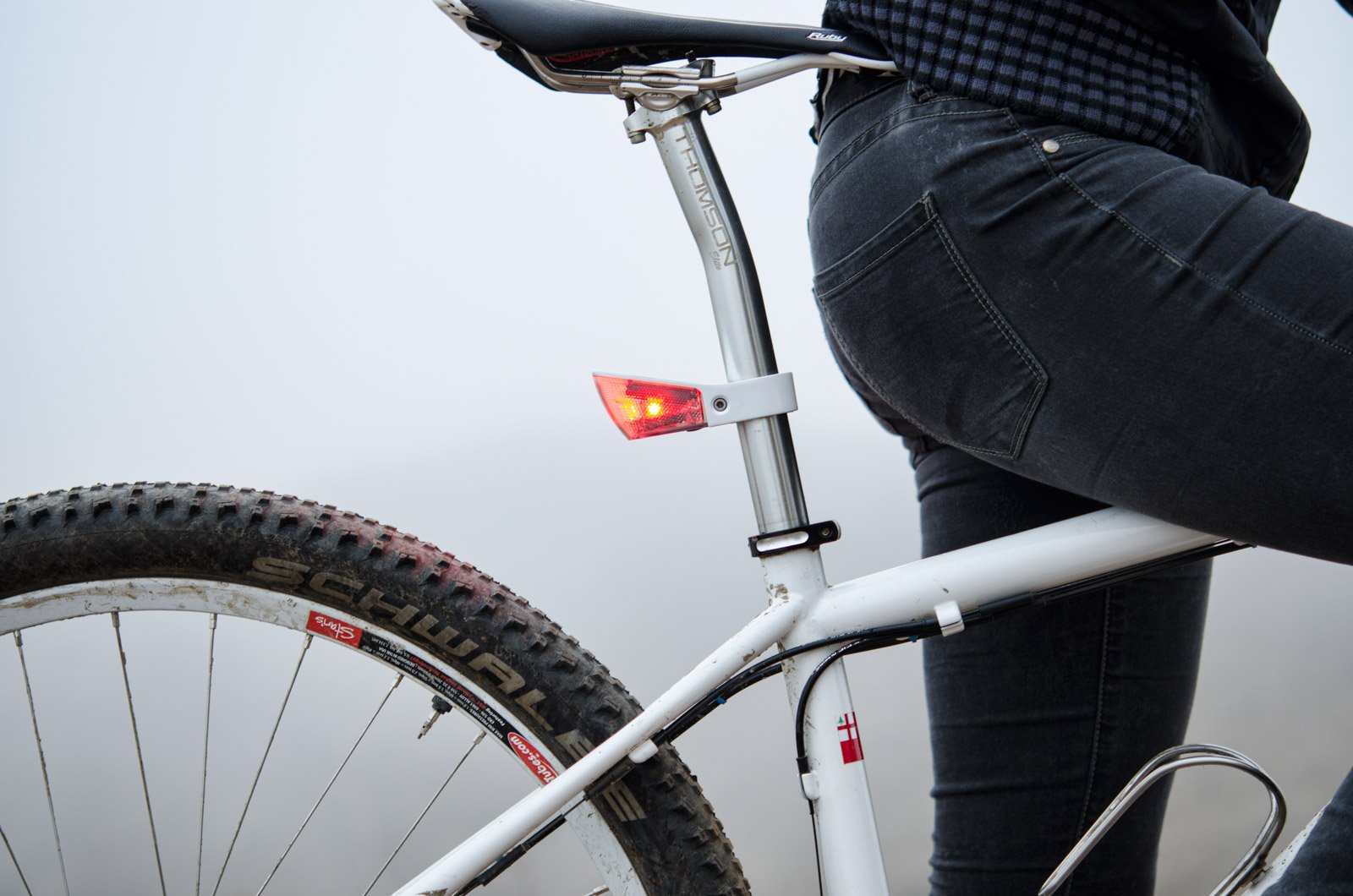 A close-up photo of a red, rear bicycle light mounted on a bike.
