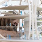 A student gazes through a close-up view of an oval-shaped architectural model.