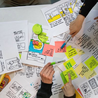 Photo of layers of Post-its and drawings with prompts and storyboarding