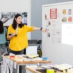 A student points to a whiteboard.