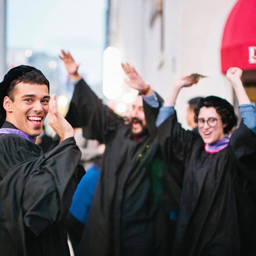 Graduating students celebrating on the street.