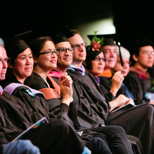 Teachers smiling as their students graduate.