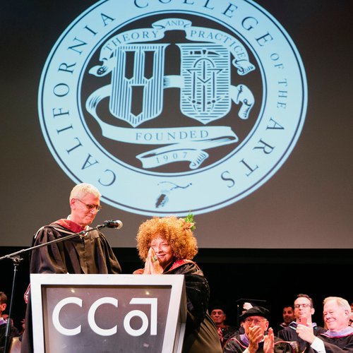Joyce J. Scott and Stephen Beal share a laugh on the graduation stage.