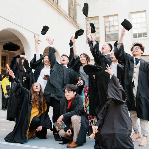 A group of graduating students throw their caps into the air.