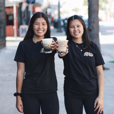 Photograph of CCA student Mickie Lau and her sister Rachel Lau holding bubble tea drinks.
