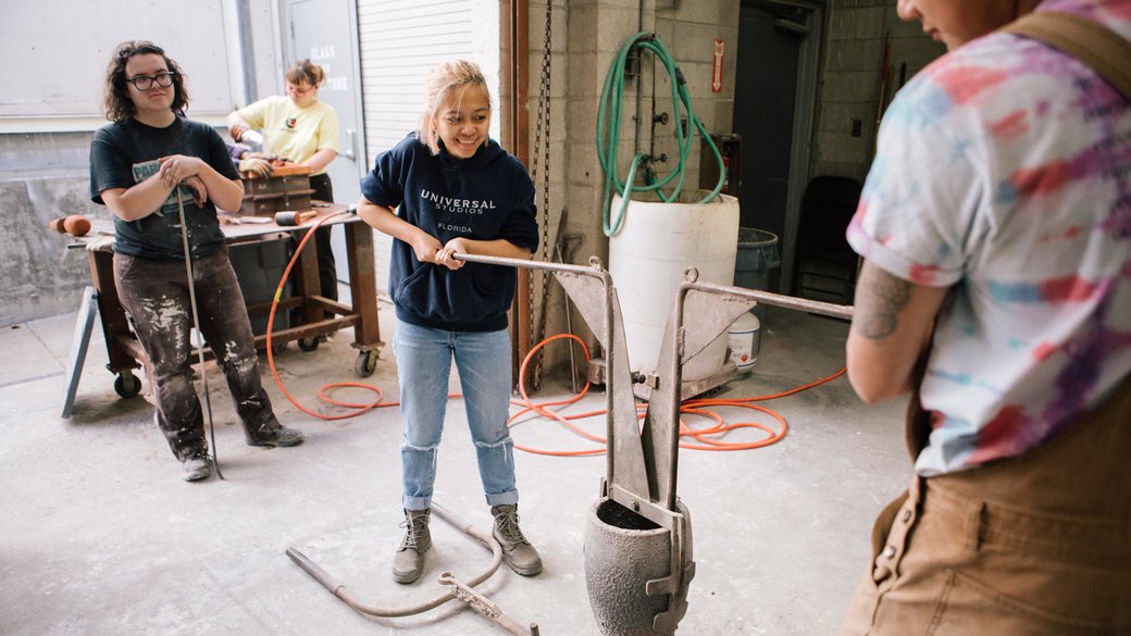 Sculpture student preparing to pour liquid bronze in the metal foundry