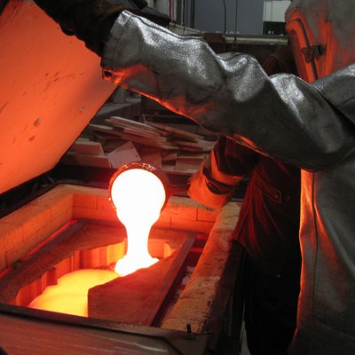Students pouring hot glass in the Barclay Simpson Kiln