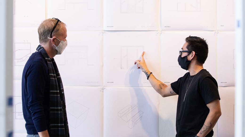 A student in the Master of Architecture program presents his work in the Nave to Dean Keith Krumwede.