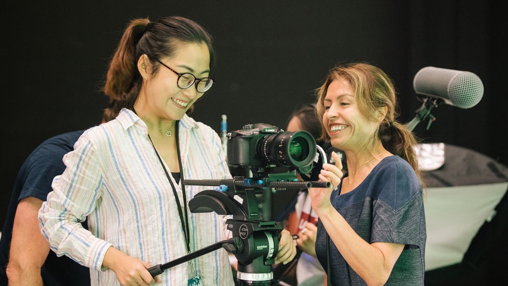 Reflected light from the greensweep casts a pallid glow upon the gleeful faces of film students as they compose their shot.