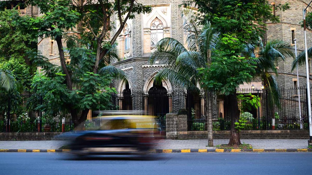 car going by some nice buildings in Mumbai