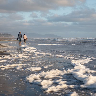 People walking on a beach at sunset