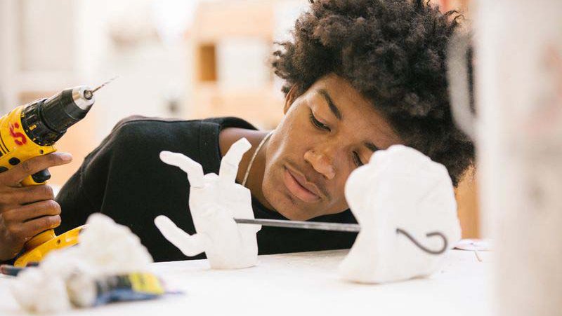 Student screwing together a ceramic sculpture in the mold lab