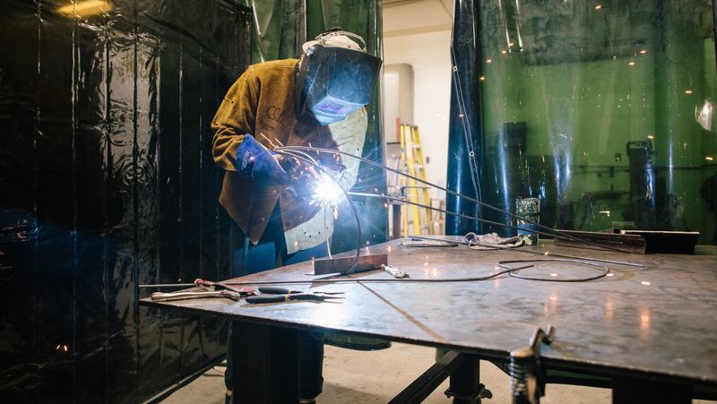 Student welding a sculpture during a metal working class