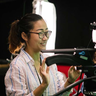 BFA Film student works with teacher to review video takes in green screen film cage